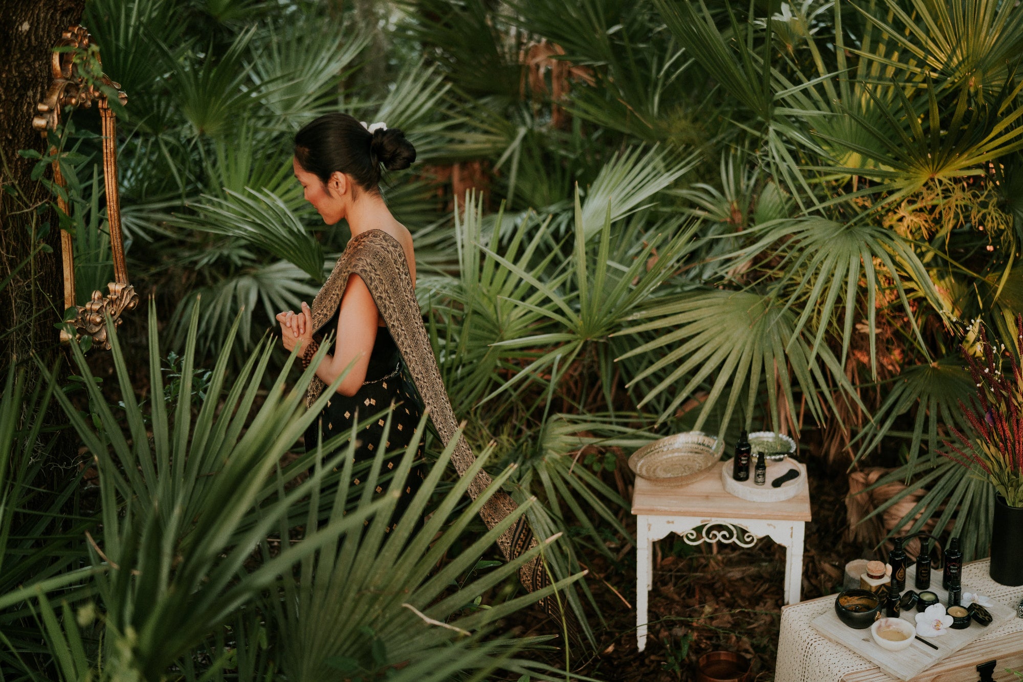 a lady doing a skin ritual in the forest in a Thai Costume